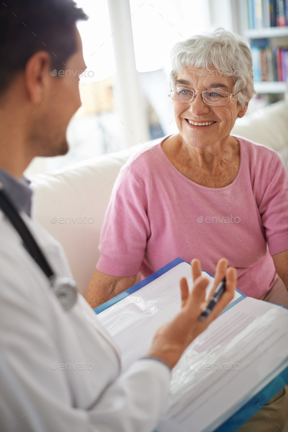 Ive got good news for you. A smiling senior woman chatting with her GP during an appointment.
