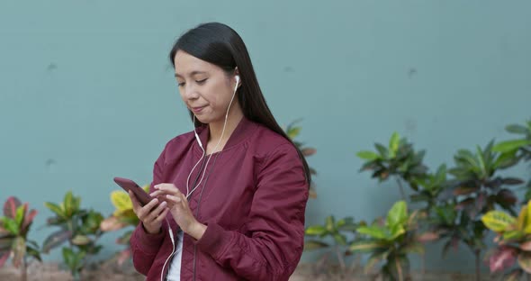 Woman listen to music on cellphone alt