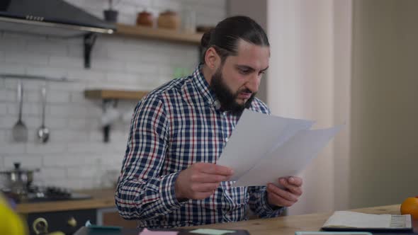Dissatisfied Angry Middle Eastern Man Tearing Documents Thinking in Home Office alt