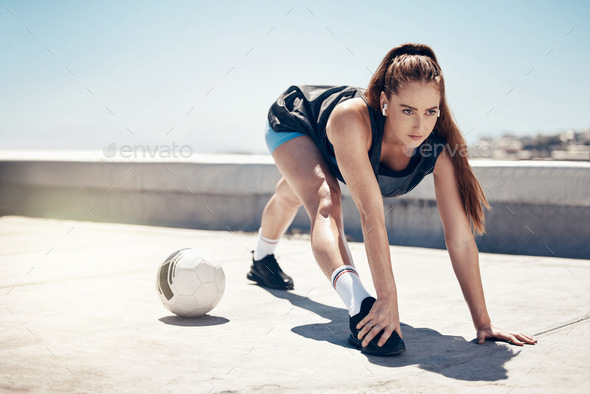 Soccer ball, stretching and woman in fitness workout, training and exercise on rooftop with music e