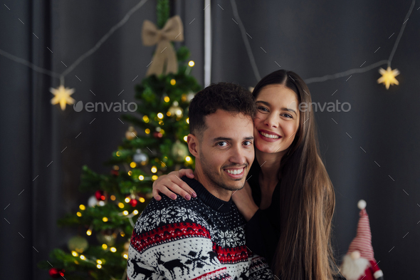 Smiling caucasian couple looking at camera at christmas - Stock Photo - Images
