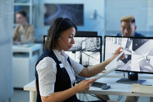 Young woman wearing headset in security center office