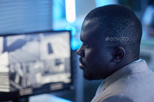 Man looking at surveillance camera feed in monitoring and security center