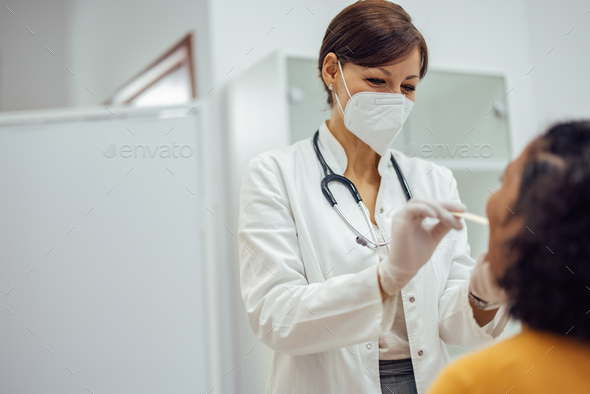 Doctor doing medical examination of a female patient\'s throat.