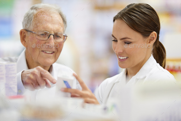 Ensuring customers find what they need. Shot of a young pharmacist helping an elderly customer.