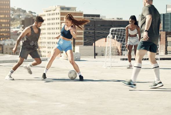Soccer, rooftop and friends happy activity bonding together with sport workout training in city. Di