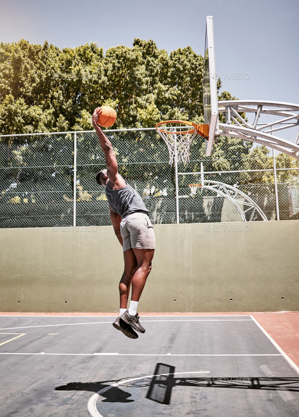 Basketball dunk, sport and strong black man athlete on a outdoor ...