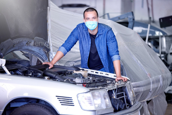 Car, face mask and a mechanic in workshop during covid, safety, and insurance at work. Working, mai