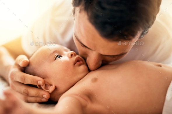You are loved my little one. Shot of a father bonding with his baby boy at home.
