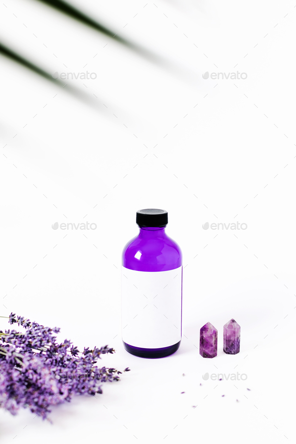 Vertical advertising picture with flowers and bottle.