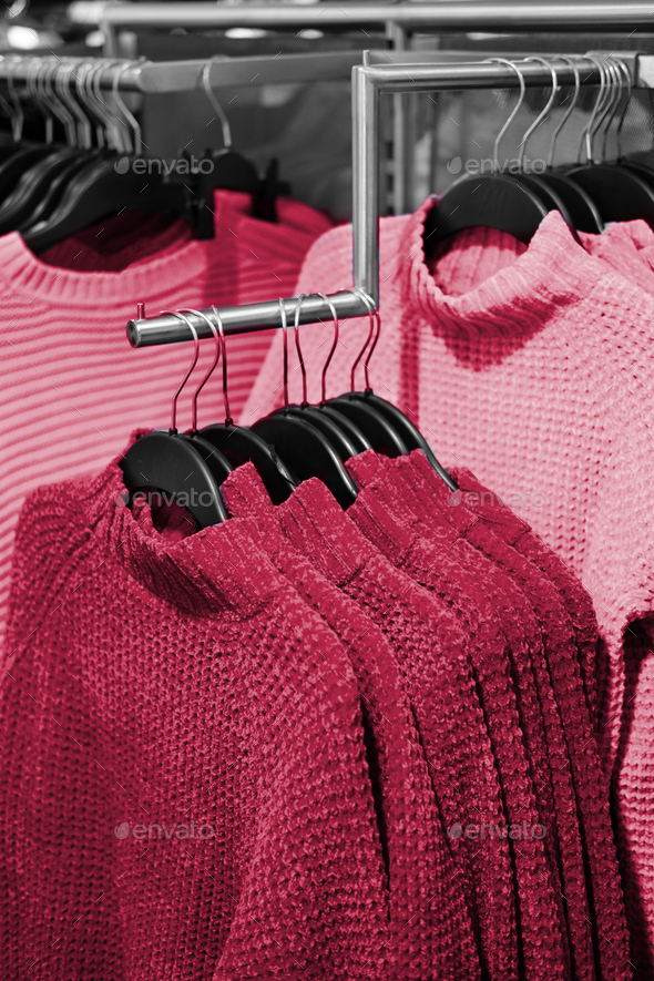 Multo color winter sweater on store shelves. New 2023 trending PANTONE 18-1750 Viva Magenta colour - Stock Photo - Images