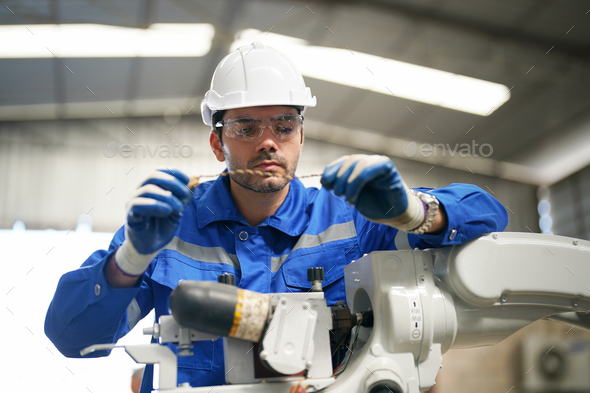 Robotics engineer operating robot aided CNC machine in robotics ...