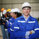 Young confident leader of team standing in front of factory workers - PhotoDune Item for Sale