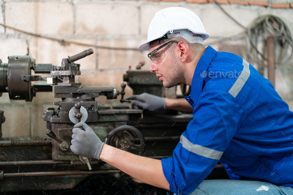 Robotics engineer fitting sensors to traditional engineering lathe in robotics research facility - Stock Photo - Images