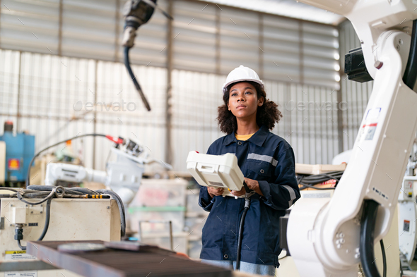 Robotics engineer operating robot aided CNC machine in robotics ...