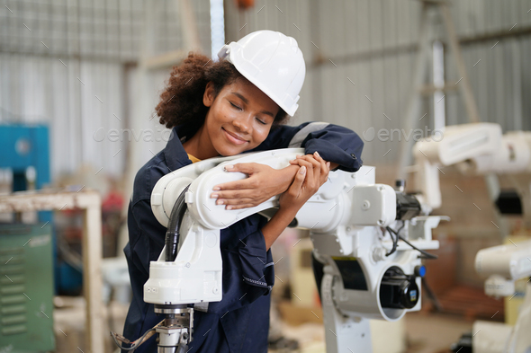 Robotics engineer operating robot aided CNC machine in robotics ...