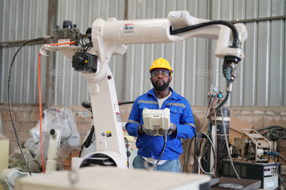 Robotics engineer operating robot aided CNC machine in robotics ...