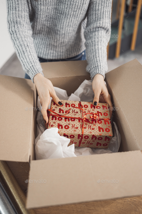 Unrecognizable woman packaging a Christmas present to send in the mail