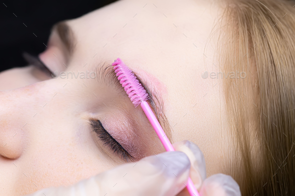 eyebrow lamination the master combs the client's eyebrows with a brush