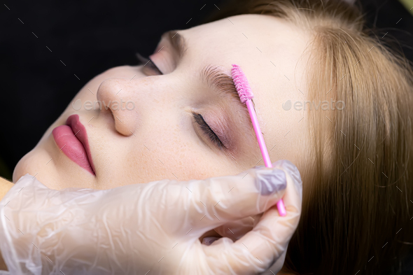 master combs the eyebrows of the model with a micro brush before the eyebrow lamination procedure