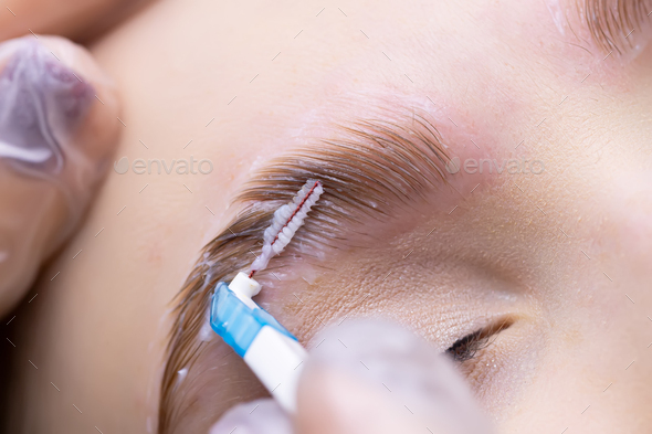 laying out the eyebrow hairs after the eyebrow lamination procedure, the master combs