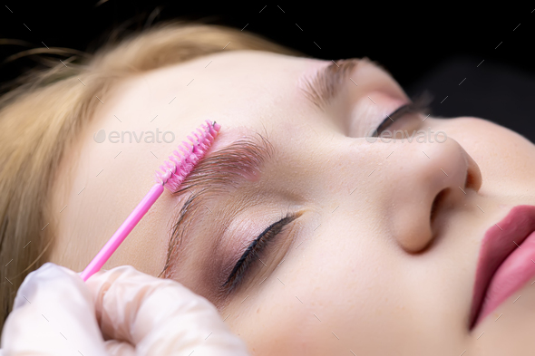eyebrow lamination procedure the master applies gel with a brush to the eyebrows of the model