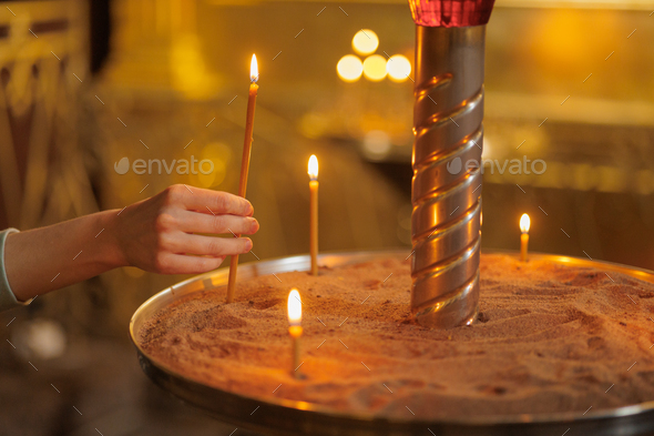 woman in the temple puts candles and prays. religion and spiritual growth. the search for truth and