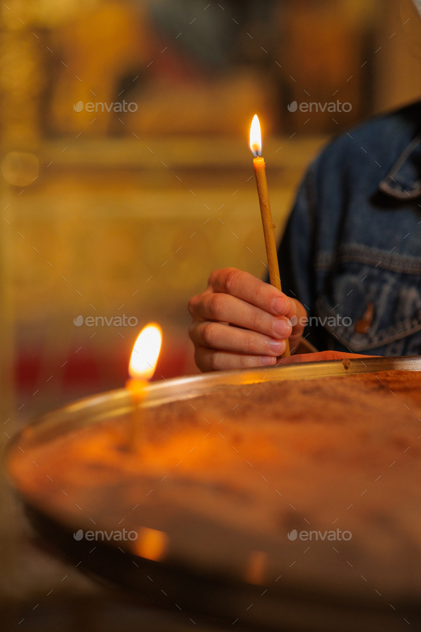 woman in the temple puts candles and prays. religion and spiritual growth. the search for truth and