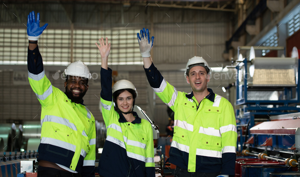 Young female engineer learning to run machinery at a factory with veteran engineers - Stock Photo - Images