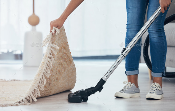 Vacuum, floor and woman cleaning under a carpet in the living room of a house. Housekeeping, servic