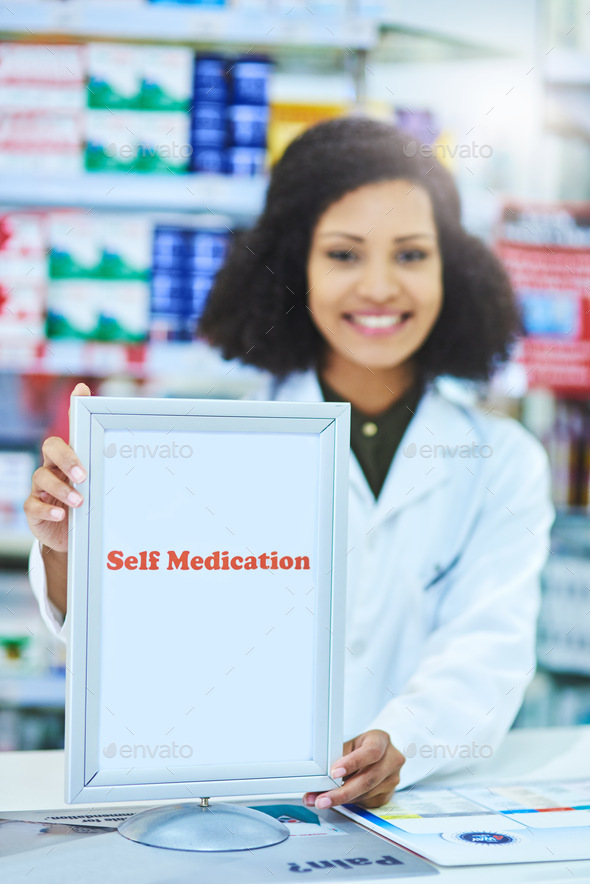Shot of a young woman showing a self medication sign at the counter of a pharmacy