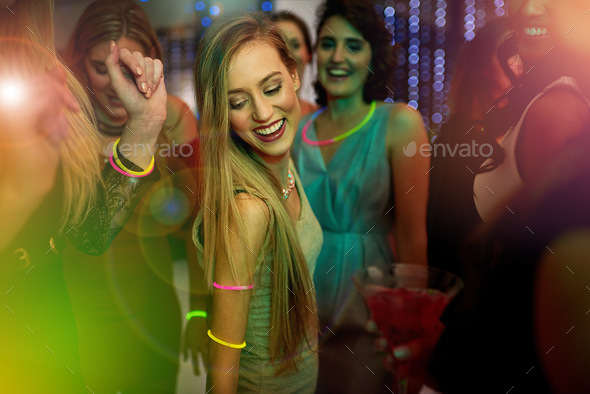 Time to let your hair down. Shot of a beautiful young woman dancing in a nightclub.