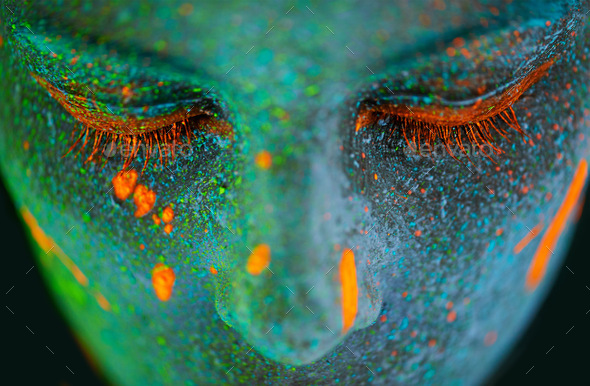 Her beauty glows in the dark. Shot of a young woman posing with neon paint on her face.