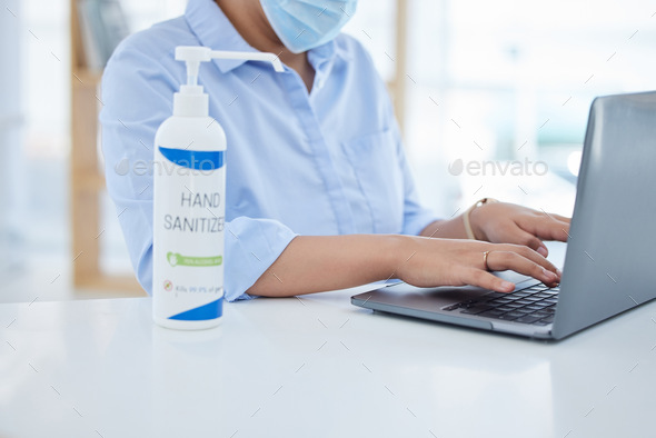 Covid, hand sanitizer and a woman typing on laptop with face mask in office. Online work, hygiene a