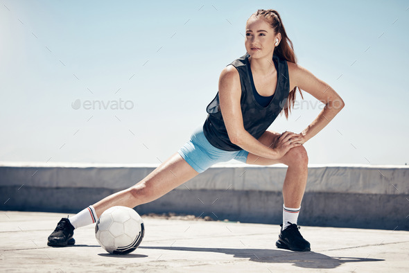 Sports, fitness and football woman stretching on a city building rooftop with a ball feeling fit, h