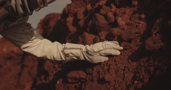Astronaut Examining Rock on Mars alt