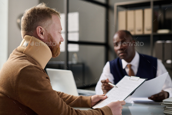 Man filling documents at insurance agency