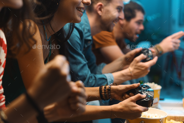 Cheerful friends playing video games together - Stock Photo - Images