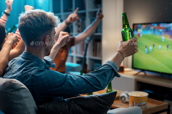 Group of friends watching a football match on TV - Stock Photo - Images