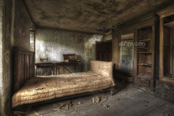 Bedroom of an abandoned house with dirty walls and broken furniture