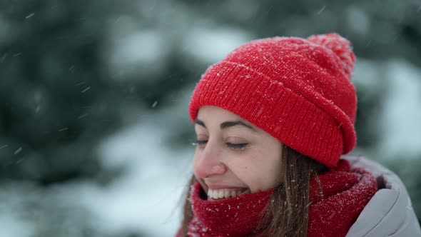 Super Close Up Happy Smiling Woman in Knitted Hat and Scarf in Snowy Winter Park at Frizzy Day with alt