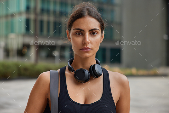 Fitness model thinks about personal goals enjoys different outdoor sport activities uses stereo head