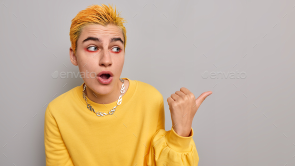 Horizontal shot of surprised extraordinary hipster girl with yellow hair bright makeup holds breath