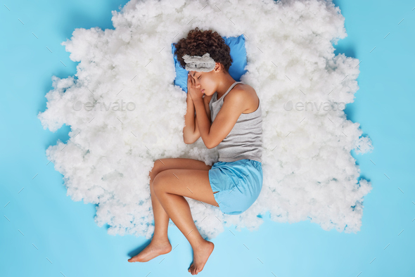 Top view of relaxed African American woman sleeps peacefully after hard working day restores energy