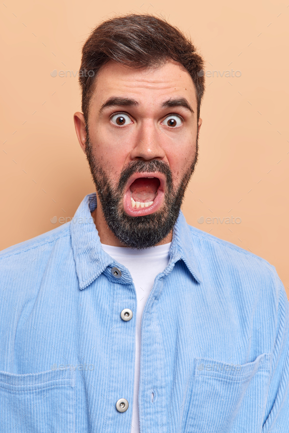 Shocked indignant bearded adult man keeps mouth wide opened looks ...