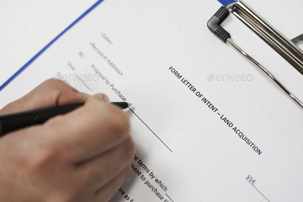 Closeup of a person signing a Form letter of intent for land acquisition - Stock Photo - Images