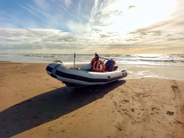 Rigid hull inflatable boat with outboard motor in the shore beaten