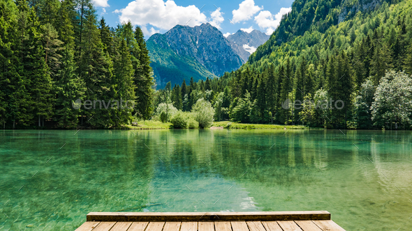 Amazing view of green lake surrounded by trees and mountains. Zgornje Jezersko, Slovenia, - Stock Photo - Images