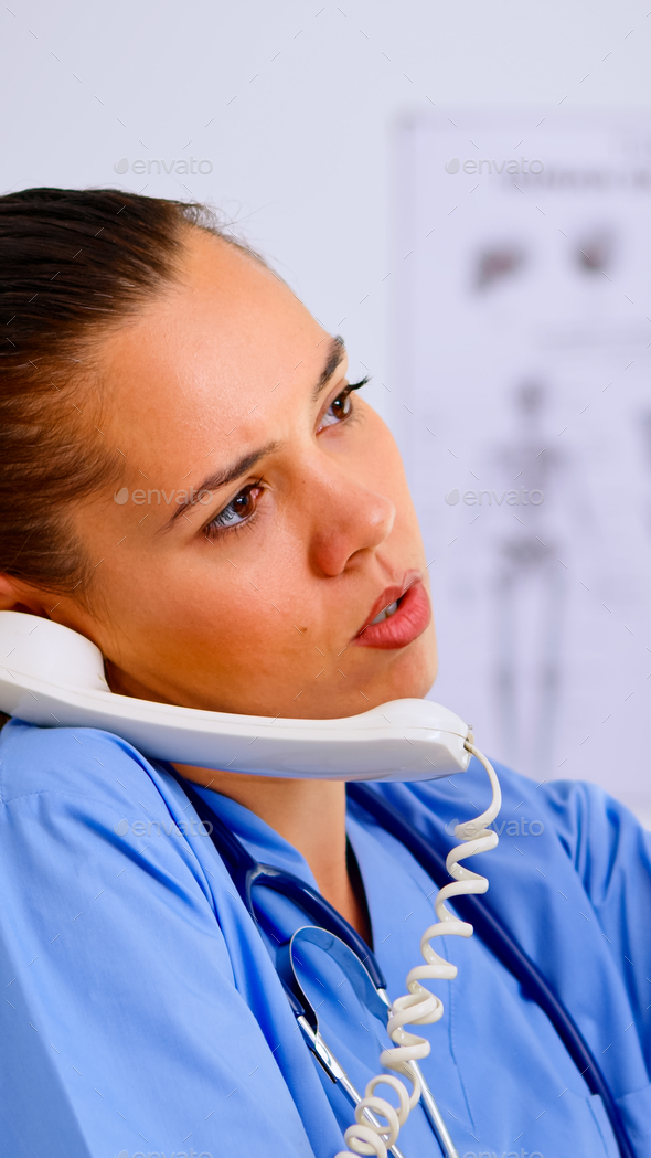 Close up of assistant answering phone checking patient x-ray