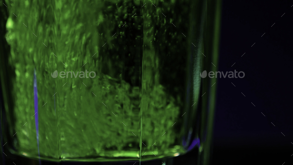 Refreshing carbonated beverage in transparent glass isolated on a colorful wall background. Clip